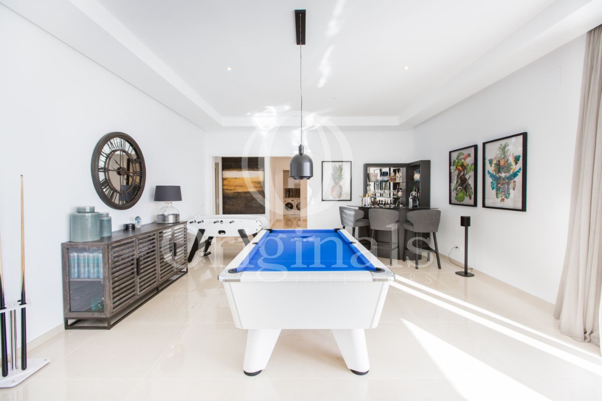 Hangout area with blue pool table, a black minibar and artworks on the wall