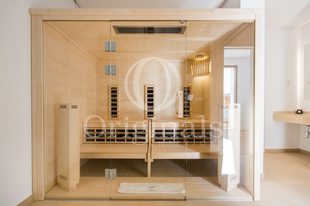 Sauna made out of light colored wood with glass walls - Originals Interiors