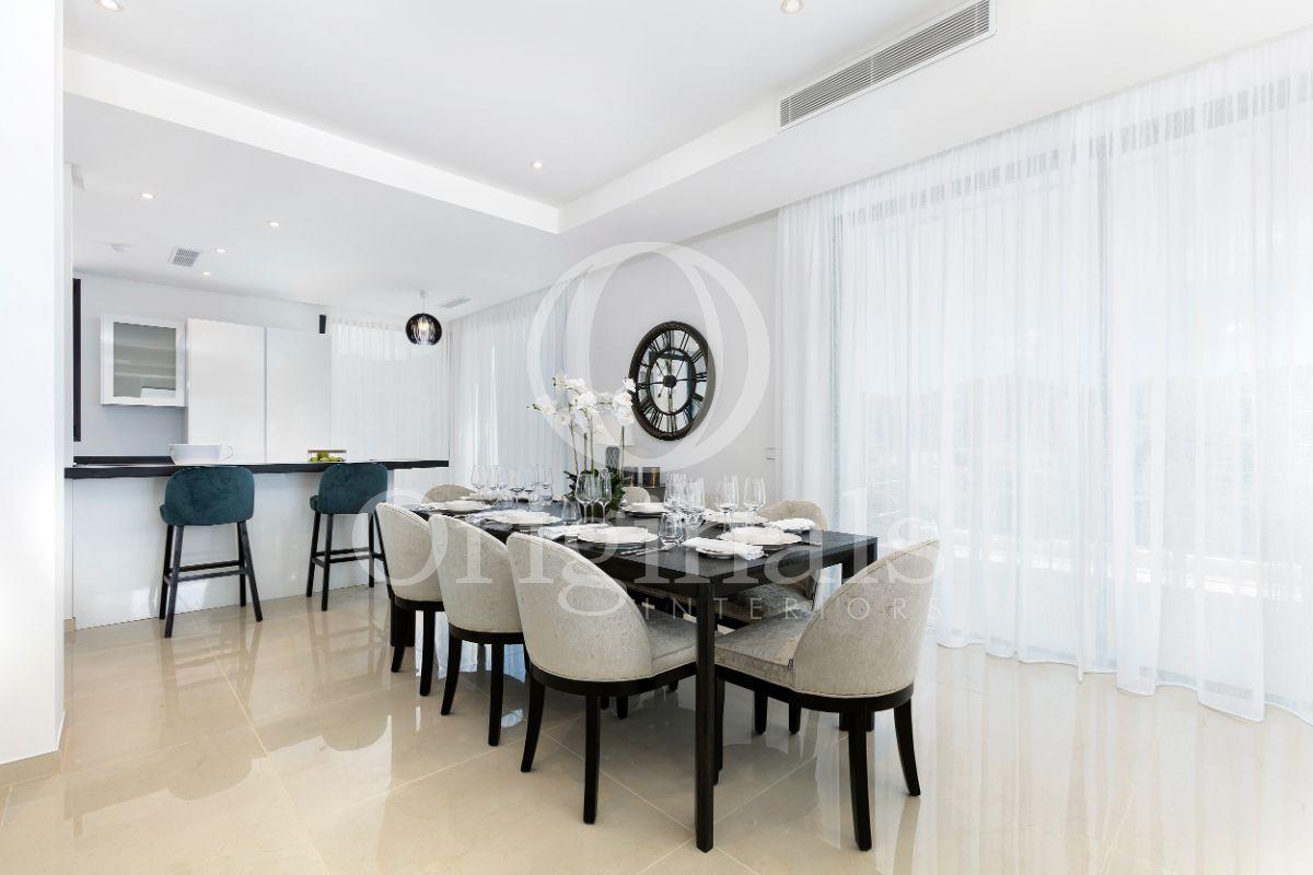 Dining area with black dining table, white chairs and white curtains - Originals Interiors