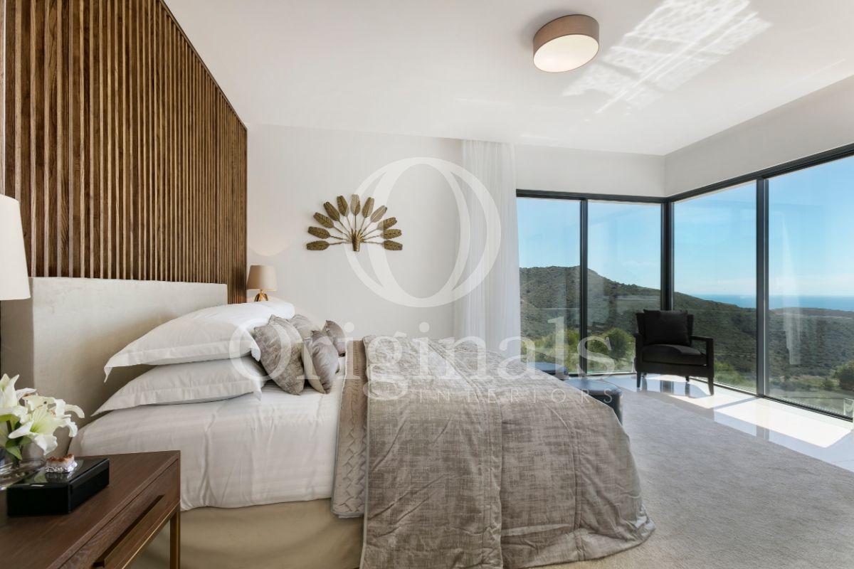 Bedroom with wooden background, grey carpet, large windows and artwork on the wall - Originals Interiors