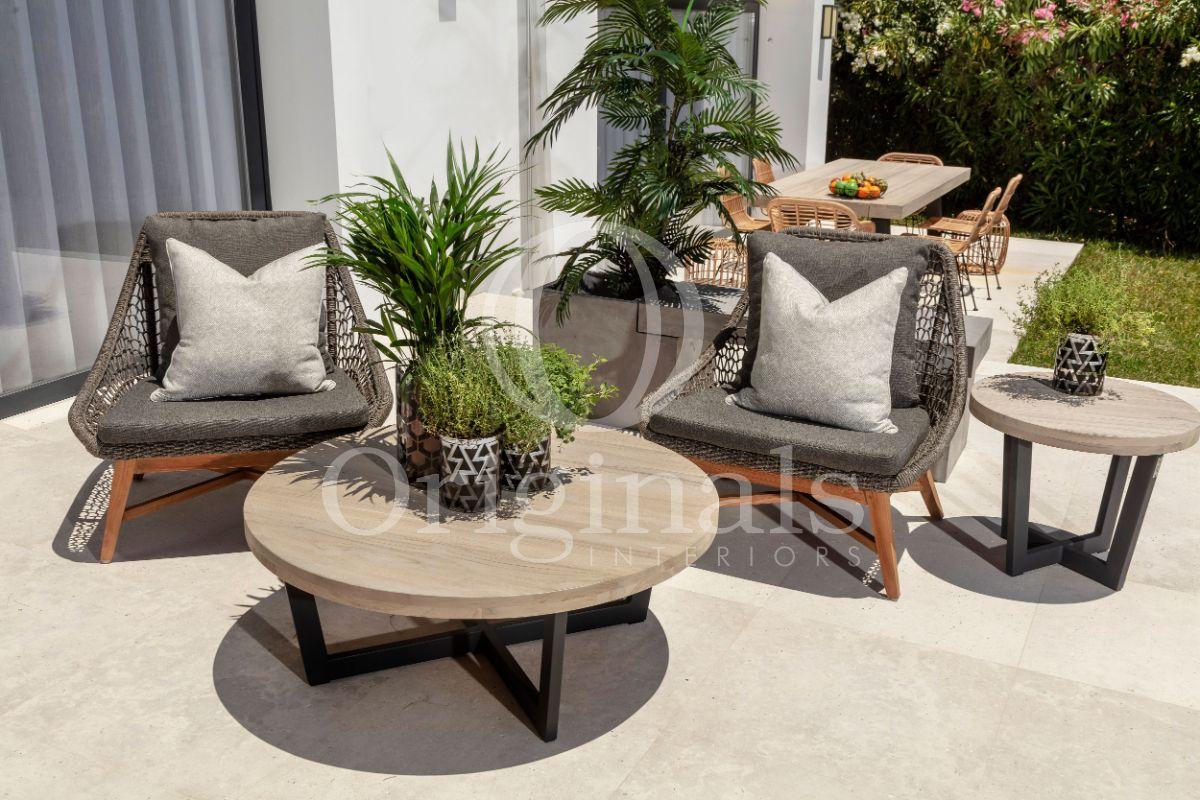 Outside lounge area with wooden round tables and small grey chairs - Originals Interiors