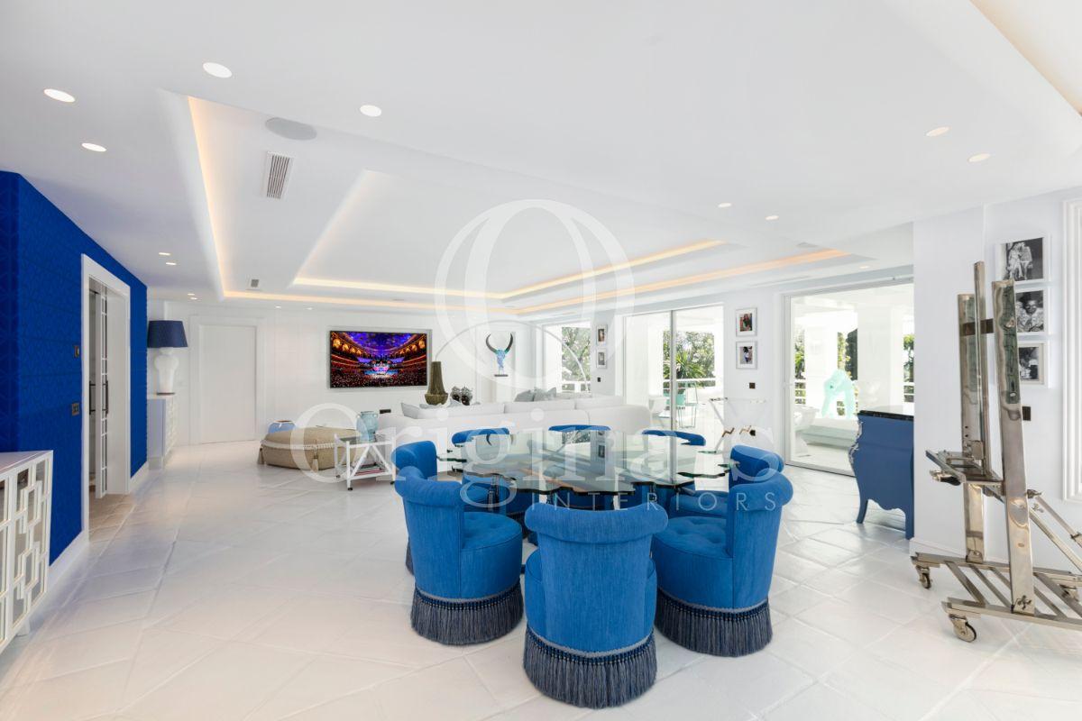 A glass dining table with blue chairs - Originals Interiors