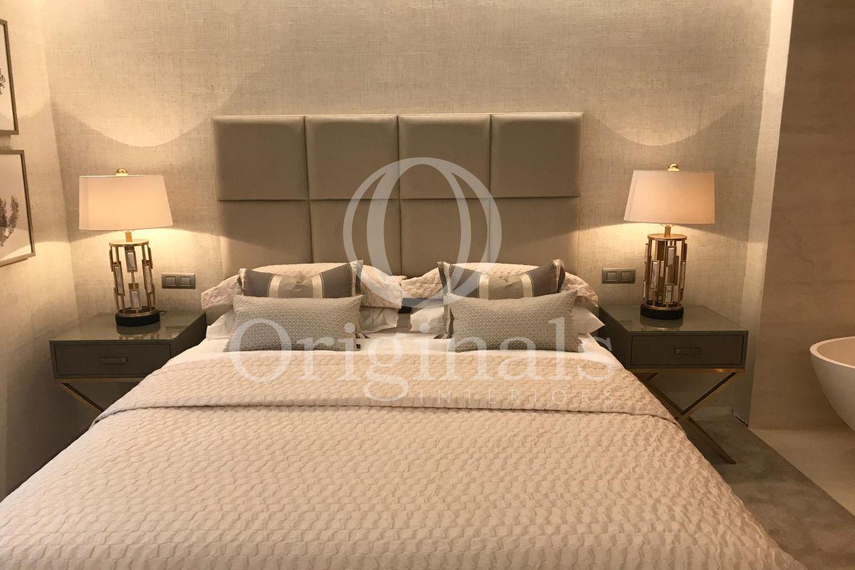 Bedroom with beige background and little dark grey shelves - Originals Interiors