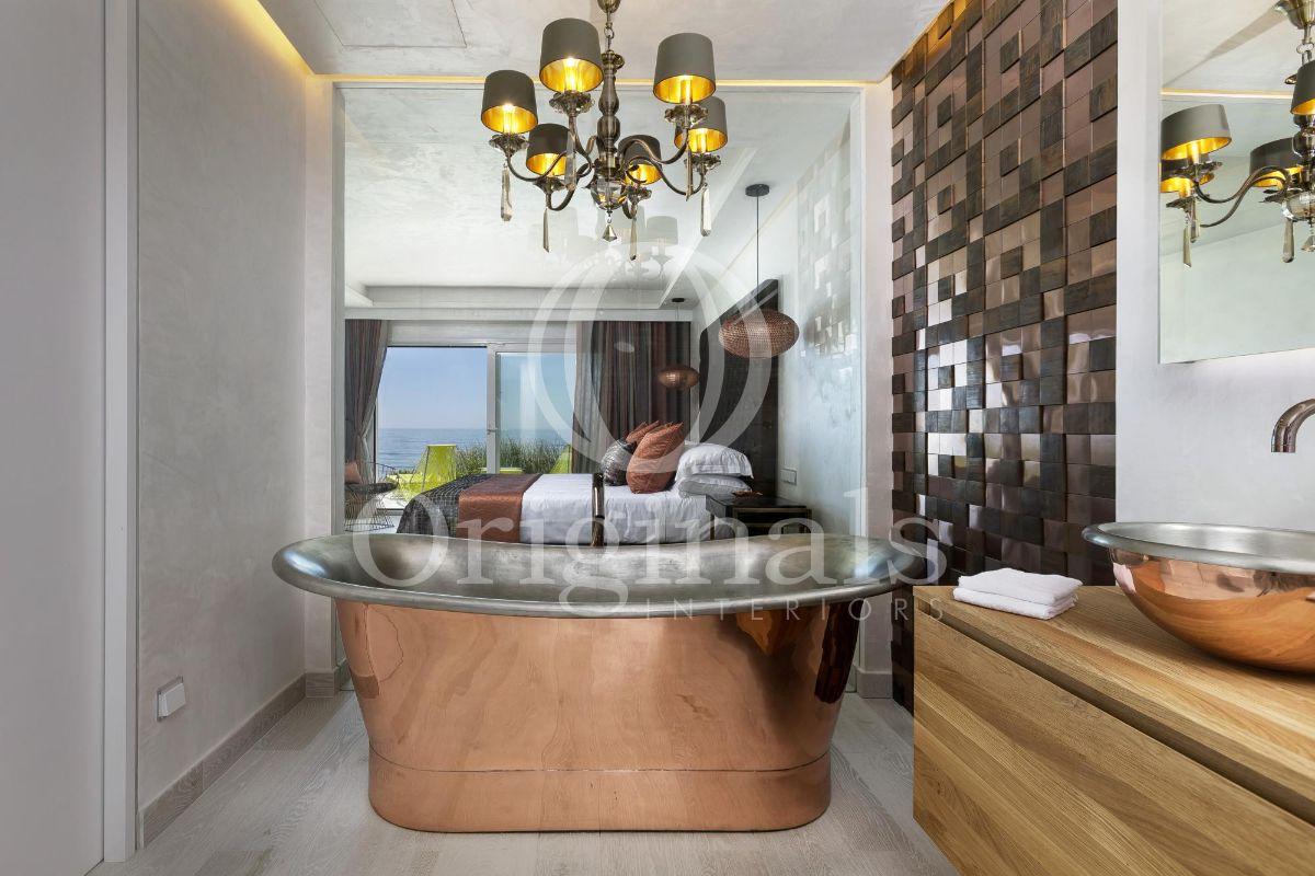 Batrhoom with metallic artistic bathtub, hanging lamps and a large mirror - Originals Interiors