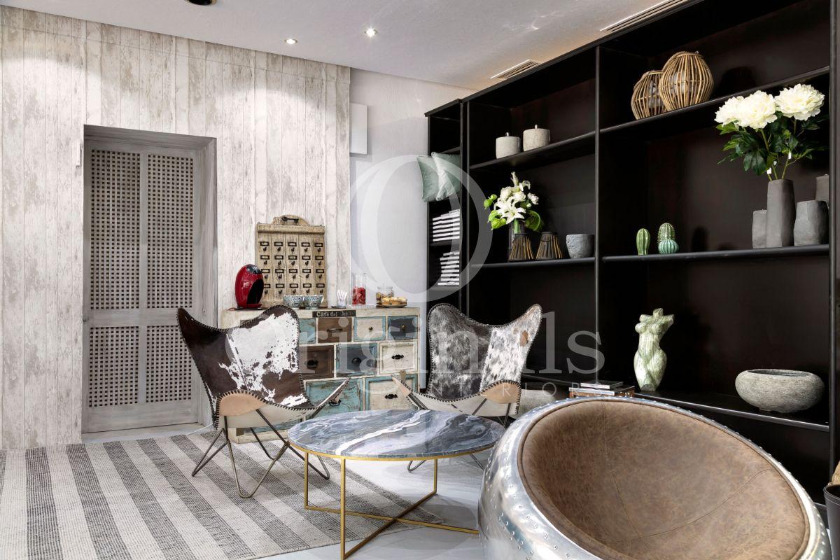 Lounge area with animal printed chairs and a large dark shelf - Originals Interiors