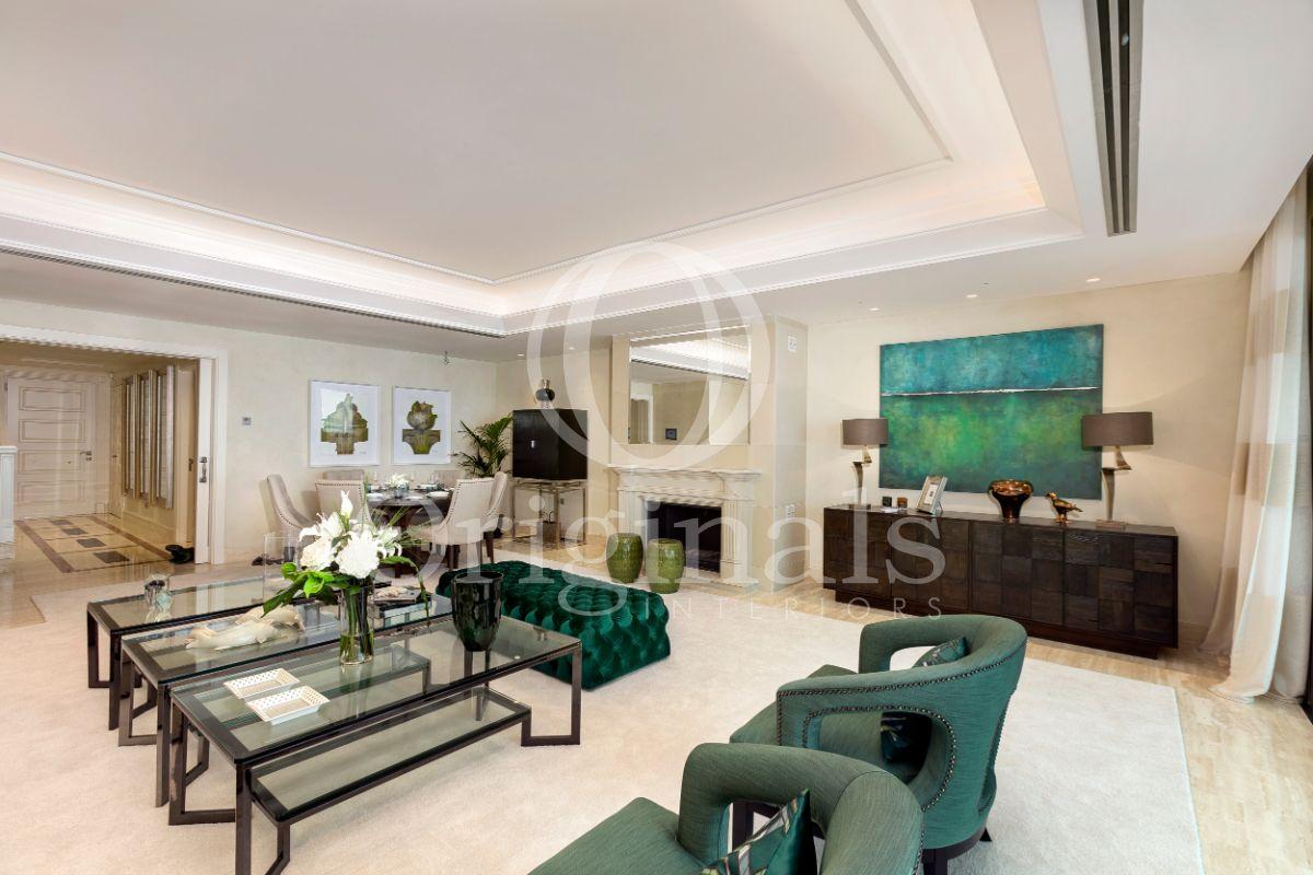 Lounge area with green chairs, glass coffee tables and a green artwork on the wall - Originals interiors