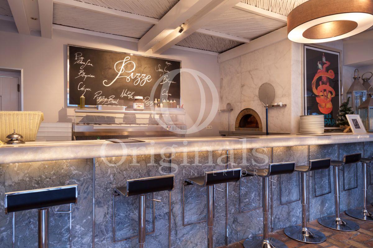 Marble bar with decorative lighting and metallic bar stools - Originals Interiors