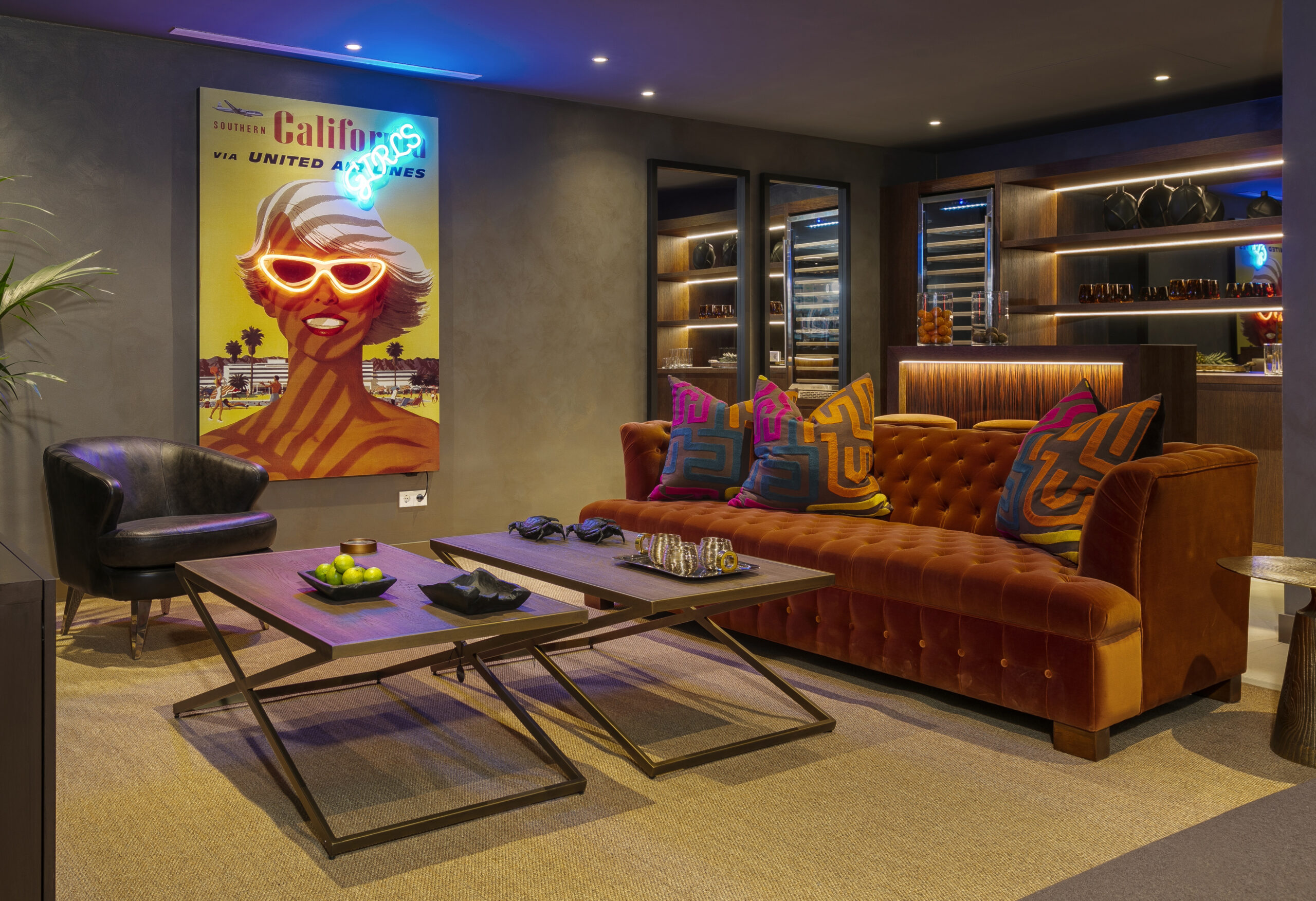 Lounge area with orange sofa, wooden bar area and dark walls - Originals Interiors
